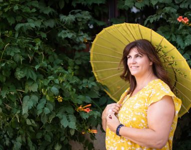 Woman holding umbrella in trees
