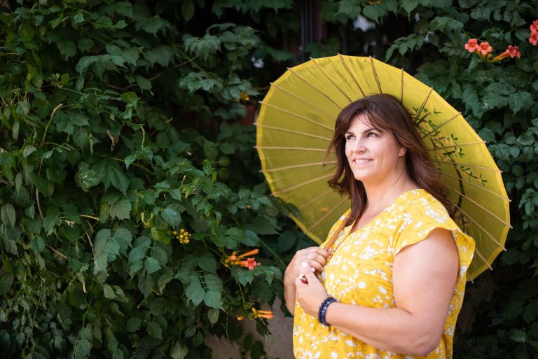 Woman holding umbrella in trees